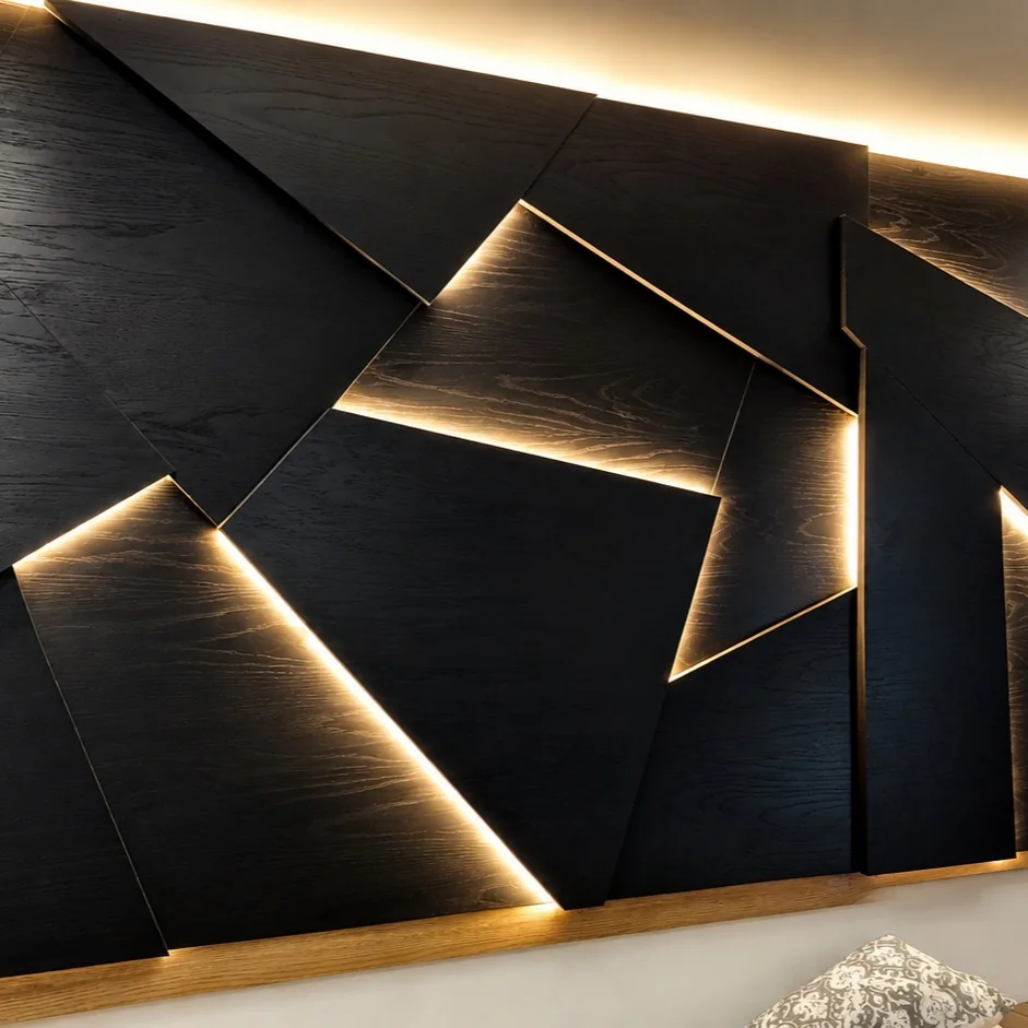 Faceted black timber feature wall with warm LED light in the joints, by AA Interiors